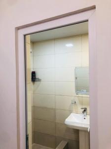 a bathroom with a sink and a shower at Kutaisi Hotel Bzholebi in Kutaisi