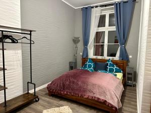 a bedroom with a bed with blue curtains and a window at Domizil in Schleiden