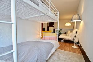ein Schlafzimmer mit einem weißen Etagenbett und einem Stuhl in der Unterkunft Akisol Troia Pearl in Troia