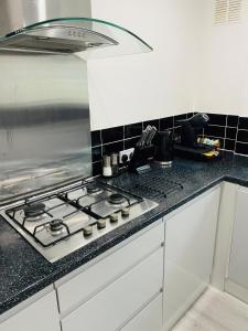 uma cozinha com uma placa de fogão e forno. em Home in Farnborough with Free Parking, Wifi & Netflix em Farnborough