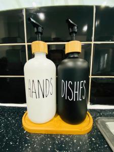 dos botellas de manos y platos sentados en un estante en Home in Farnborough with Free Parking, Wifi & Netflix, en Farnborough
