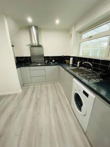 una cocina con lavadora y secadora. en Home in Farnborough with Free Parking, Wifi & Netflix en Farnborough