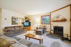 uma sala de estar com dois sofás e uma lareira em Trail Creek 43 em Killington