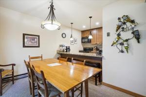 a dining room and kitchen with a wooden table and chairs at Trail Creek 43 in Killington
