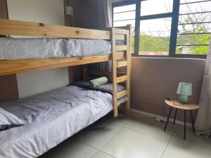 a bedroom with two bunk beds and a window at The Cottage on Roy Wright in Umkomaas