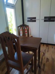 depto muy cómodo en 1er piso في لا بلاتا: طاولة خشبية وكرسيين في مطبخ