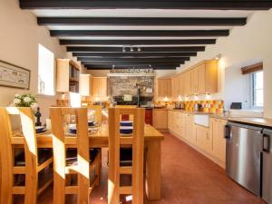 eine große Küche mit einem Holztisch und Stühlen in der Unterkunft 3 bed property in Blair Atholl 78841 in Trinafour