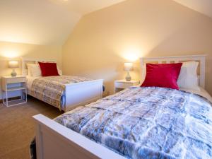 1 Schlafzimmer mit 2 Betten und roten Kissen in der Unterkunft 3 bed property in Blair Atholl 78841 in Trinafour
