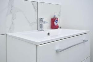 a bathroom with a white sink and a mirror at Lyndale House - By Sigma Stays in Crewe