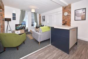 a living room with a kitchen and a living room with a couch at Lyndale House - By Sigma Stays in Crewe