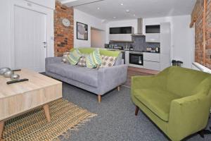 a living room with a couch and a chair at Lyndale House - By Sigma Stays in Crewe
