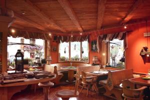 a dining room with orange walls and tables and chairs at Hotel Piccolo Tibet in Livigno