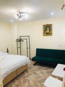a bedroom with a bed and a green couch at Kutaisi Hotel Bzholebi in Kutaisi