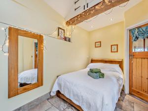 1 dormitorio con cama y espejo en 1 Bed in Westward Ho GATAB en Bideford