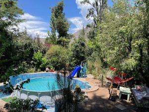 una piscina en medio de un patio con árboles en Acogedora cabaña entre montañas en San Alfonso