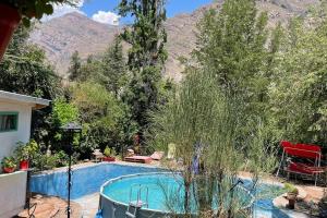 una piscina en un patio con montañas al fondo en Acogedora cabaña entre montañas en San Alfonso