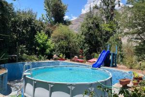 uma piscina com escorrega num jardim em Acogedora cabaña entre montañas em San Alfonso