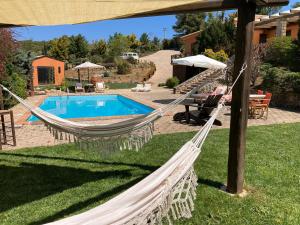 a hammock in a yard next to a pool at Maison Christine Villa in Varnávas +14 photos
