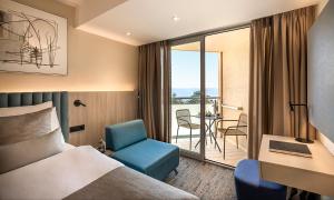 a hotel room with a bed and a desk and a chair at Aminess Vival Maestral Hotel in Novigrad Istria