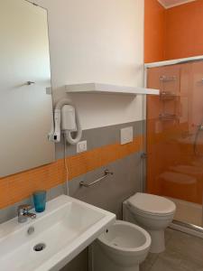 bagno con lavandino bianco e servizi igienici di Viva a Porto Cesareo