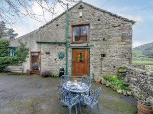 a table and chairs in front of a stone building at 2 Bed in Sedbergh 57641 in Dent