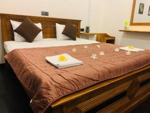Una cama con dos toallas y flores. en Beacon en Hikkaduwa