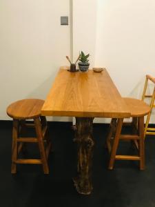 einem Holztisch mit zwei Stühlen und einer Pflanze darauf in der Unterkunft Beacon in Hikkaduwa