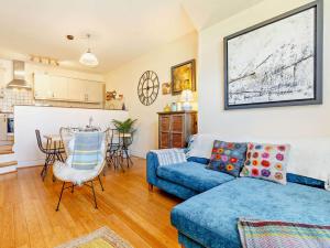 a living room with a blue couch and a kitchen at 1 Bed in Gulval 88293 in Gulval