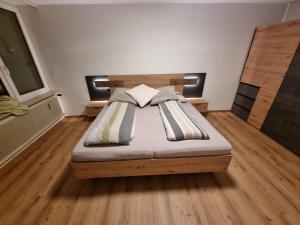 1 dormitorio con 1 cama en una habitación con suelo de madera en Gerlitzen, Kanzelhöhe, Über den Wolken, Haus Enzian, en Deutschberg