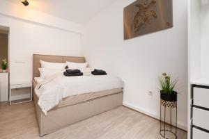 een witte slaapkamer met een groot bed met witte kussens bij Primero City-Loftdomizil Innenstadt 84qm Netflix in Augsburg