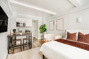 a white bedroom with a bed and a kitchen at 73-1004 New Studio UWS Doorman Gym in New York