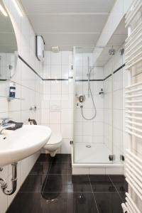 a white bathroom with a shower and a sink at Primero City-Loftdomizil Innenstadt 84qm Netflix in Augsburg