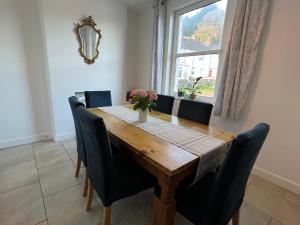 a dining room table with chairs and a window at Bluebell Cottage Mumbles - Sea Views in The Mumbles