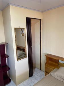 a bedroom with a mirror on the wall and a bed at HOSTEL CASA MARINA in Puerto Limón