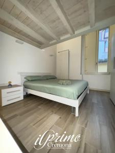 1 dormitorio con 1 cama y suelo de madera en il Primo, en Cremona