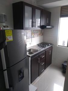 a kitchen with a stainless steel refrigerator and a sink at Apartamento Amoblado Alameda del Rio Barranquilla in Barranquilla