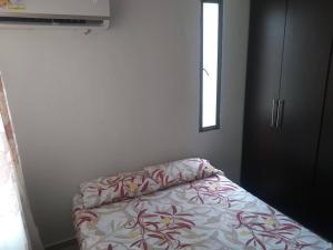 a bedroom with a bed and a window at Apartamento Amoblado Alameda del Rio Barranquilla in Barranquilla