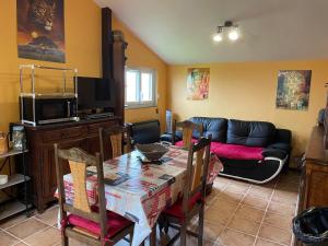 a living room with a table and a couch at LE PETIT CHALET DE SYLVIANE in Budelière +6 photos