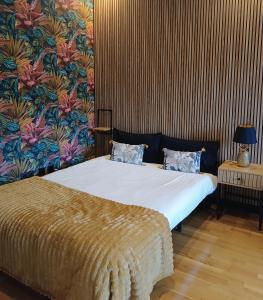 1 dormitorio con cama y papel pintado con motivos florales en Fridda House Oviedo Hospital, en Oviedo