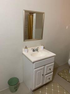 a bathroom with a white sink and a mirror at Beach Walk Studio near Mobay Hip Strip in Montego Bay