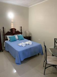a bedroom with a blue bed with towels on it at Beach Walk Studio near Mobay Hip Strip in Montego Bay