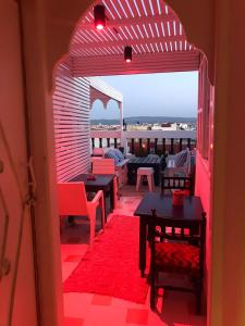 an open door to a patio with tables and chairs at Hôtel Riad Gnaoua in Essaouira