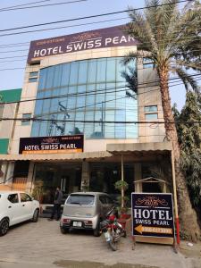 a hotel with a motorcycle parked in front of a building at Hotel Swiss Pearl in Lahore