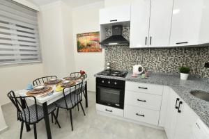 a kitchen with white cabinets and a table with chairs at Center Suite 8 in Istanbul
