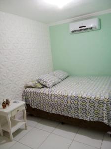 Dormitorio pequeño con cama y mesa en Casa do breno, en Paraipaba