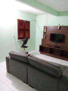sala de estar con sofá y TV de pantalla plana en Casa do breno, en Paraipaba