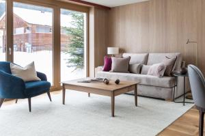 ein Wohnzimmer mit einem Sofa und einem Couchtisch in der Unterkunft Hotel Schranz in Lech am Arlberg