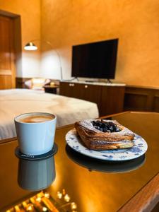 eine Tasse Kaffee und ein Gebäck auf dem Tisch in der Unterkunft Casa H Hotel Boutique in San Luis Potosí