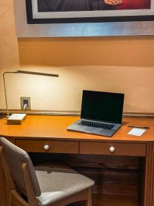 a laptop computer sitting on top of a wooden desk at Casa H Hotel Boutique in San Luis Potosí