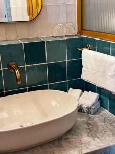 a bathroom with a white tub and a blue tiled wall at Casa H Hotel Boutique in San Luis Potosí